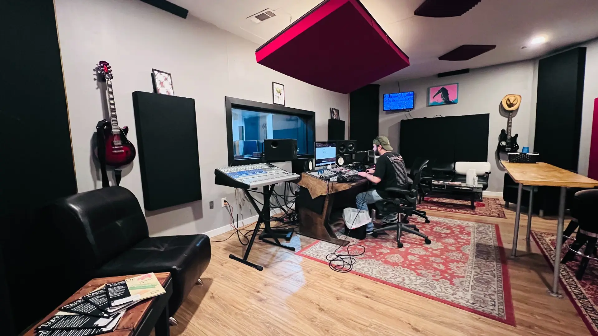 Wide view of Studio A’s control room, showing the mixing desk, monitors, acoustic panels, and seating